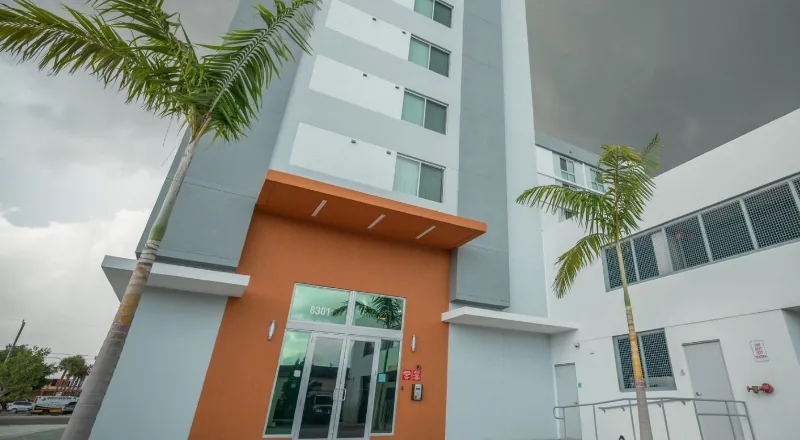 Storefront entry set into a stucco elevation on a multi-storey building.