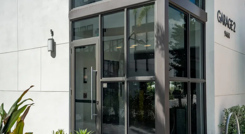 A full-height glazed lobby enclosure with a single commercial leaf.